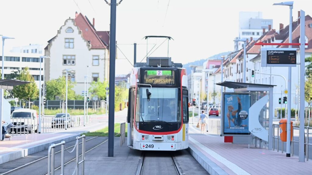 Eine Straßenbahn der Linie 4 steht an einer Haltestelle in der Waldkircherstraße